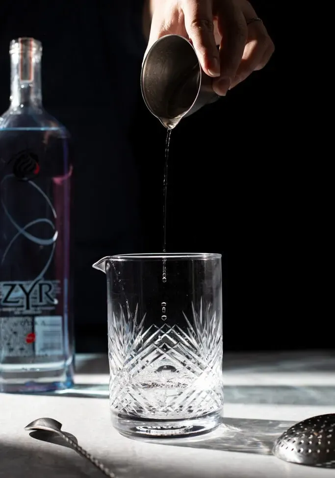 gouttelettes de vodka tombant dans un verre à mélange.' loading='lazy' title=