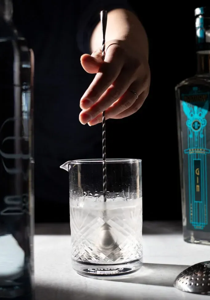 Remuer un cocktail dans un verre à mélange.' title=