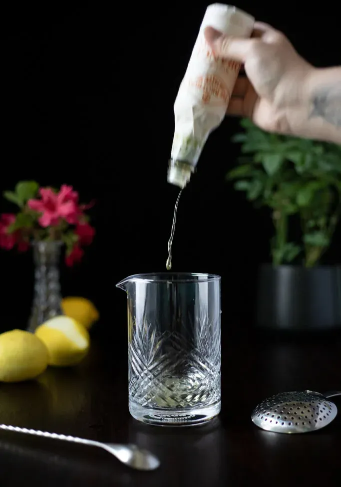 odrobina orange Bitters wpadająca do szklanki miksującej.' loading='lazy' title=
