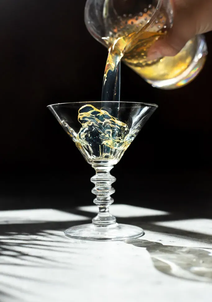 vertiendo el martini en un vaso.' loading='lazy' title=