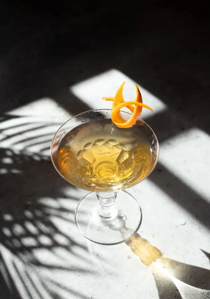un martini de color amarillo con un elegante toque de naranja.' loading='lazy' title=