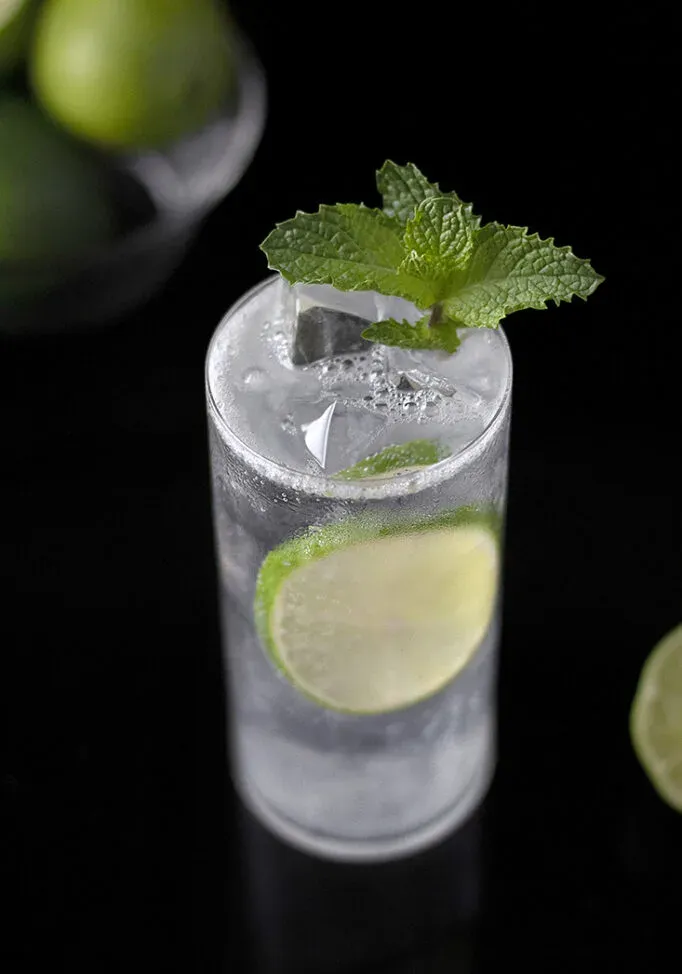 cocktail dans un verre highball à la menthe et au citron vert.' loading='lazy' title=