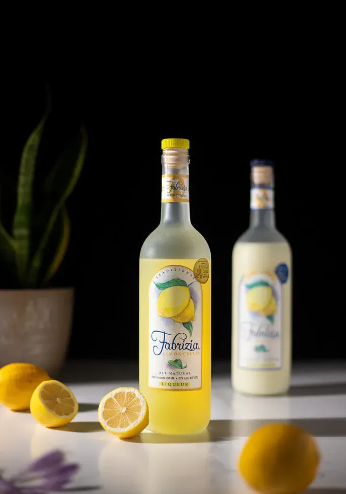 בקבוק פבריציה לימונצ'לו עם לימונים.' loading='lazy' title=