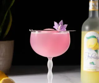 משקה ורוד בכוס קופה וינטג' גדולה.' title=