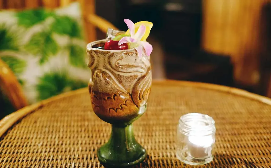 brauner und grüner Tiki-Becher aus Porzellan in Form eines Vogels.' loading='lazy' title=