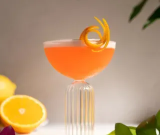 jasne oranžová tekutina v elegantnom pohári kupé s efektným oranžovým nádychom.' title=