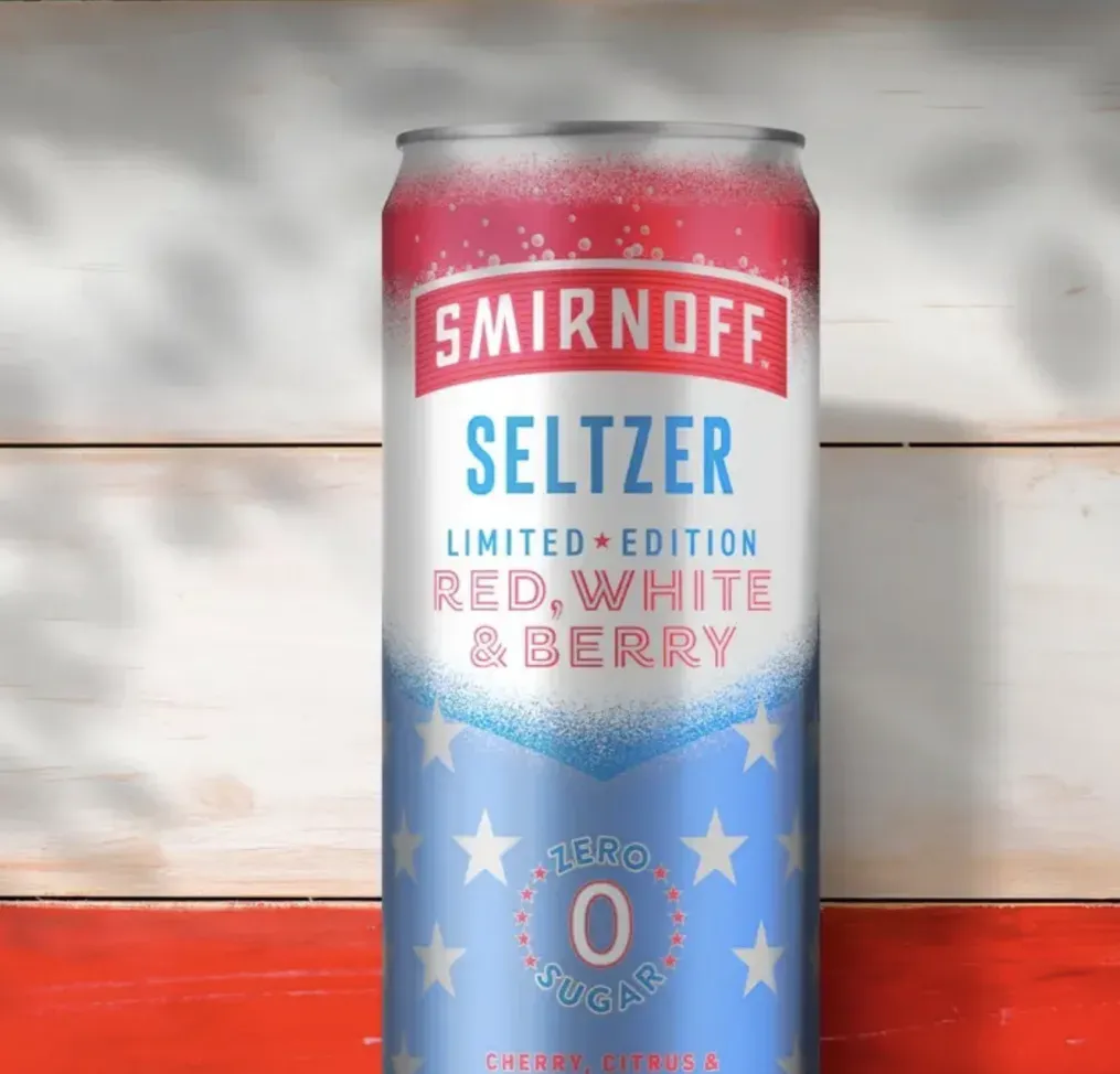 una lata de seltzer Smirnoff roja, blanca y azul sobre un fondo de madera roja y blanca.' title=