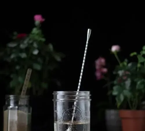 un frasco de almíbar simple con una cuchara' title=