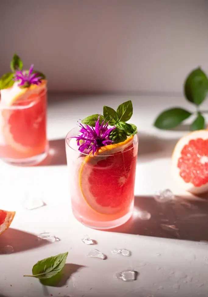 Ansicht von oben nach unten mit rosa Blüten und Basilikumblattgarnitur.' title=