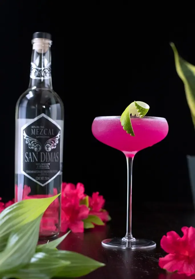 hotový kokteil z kaktusových kvetov vedľa fľaše San Dimas Mezcal' title=