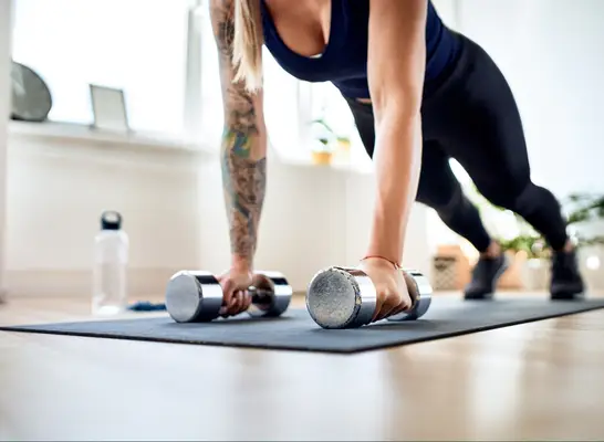 woman doing dumbbell pushups to lose belly fat in 30 days