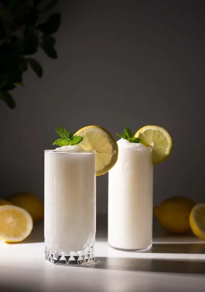 dva poháre bielej mrazivej limonády s kolieskami citróna a mätou.' title=