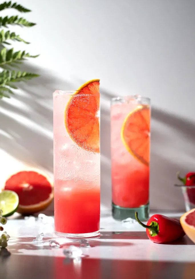 bebidas en vasos altos adornados con rodajas de pomelo.' title=