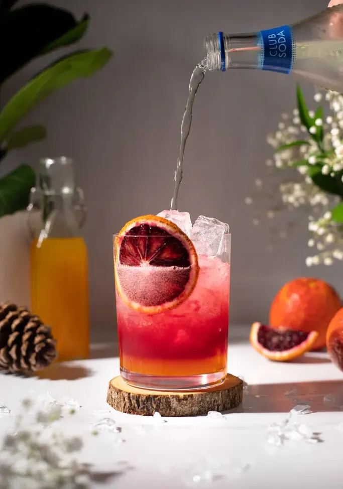 מוזגים קלאב סודה לתוך המיץ והסירופ.' loading='lazy' title=