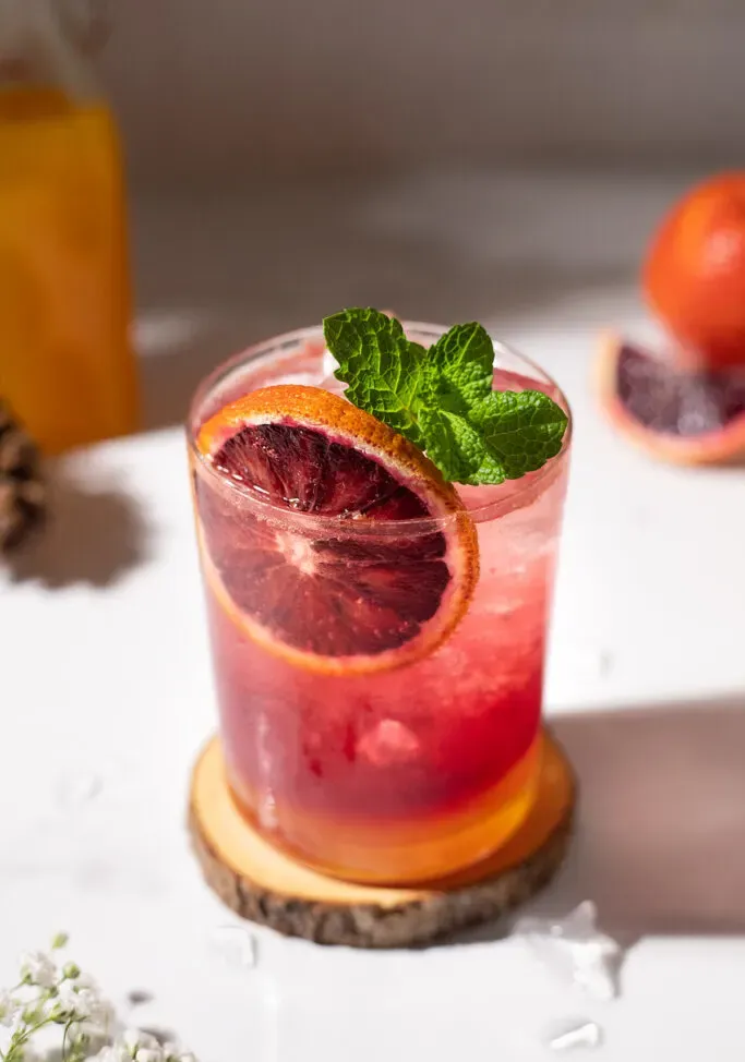 מקרוב של גלגל תפוז הדם וענף נענע.' title=