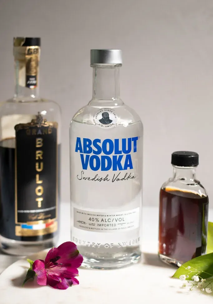 butelka wódki Absolut obok likieru kawowego i brązowego syropu.' loading='lazy' title=