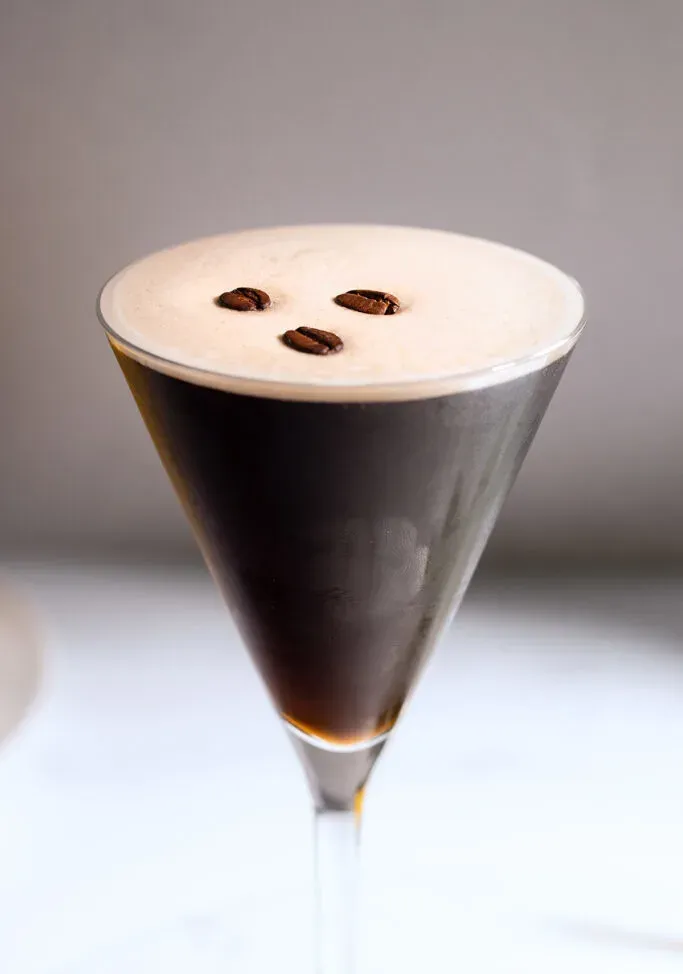zbliżenie ciemnobrązowego koktajlu espresso w szklance martini.' title=