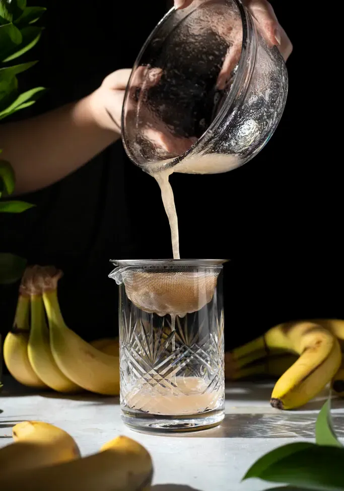 verter almíbar de un tazón en un colador de malla' title=