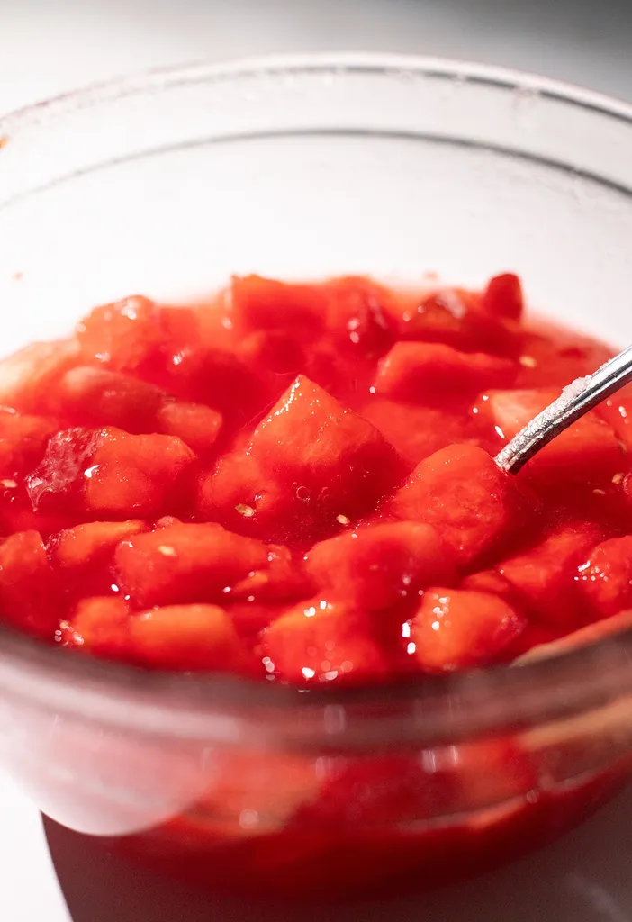 zbliżenie kawałków arbuza w syropie w szklanej misce.' loading='lazy' title=