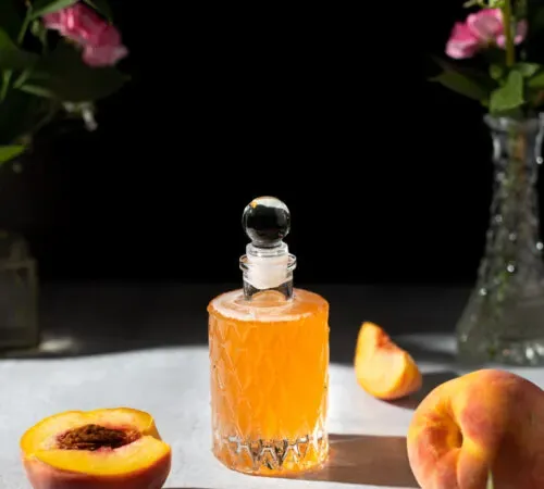 복숭아 시럽이 담긴 고급 유리병.' title=