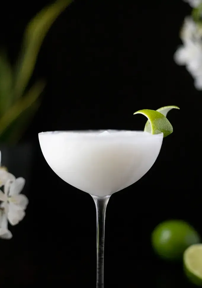 zblízka bílého zmrazeného koktejlu v koktejlové sklenici na černém pozadí' loading='lazy' title=