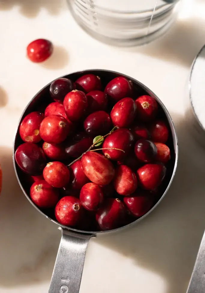 zblízka odmerku plnú čerstvých brusníc.' loading='lazy' title=