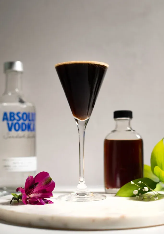 espresso martini accanto a una bottiglia di vodka.' loading='lazy' title=