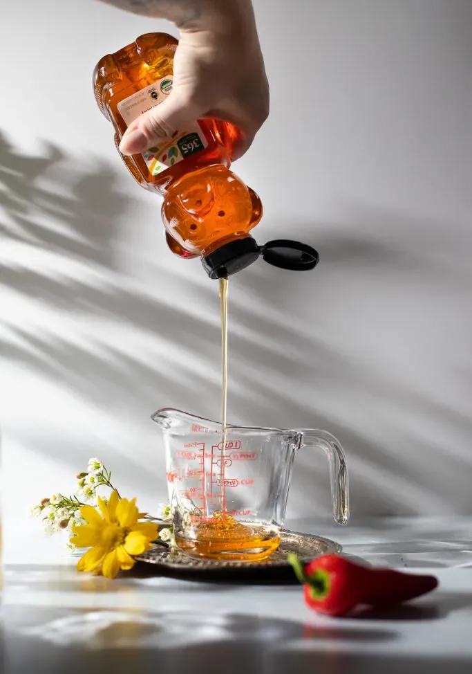 espremendo mel em um copo medidor' loading='lazy' title=