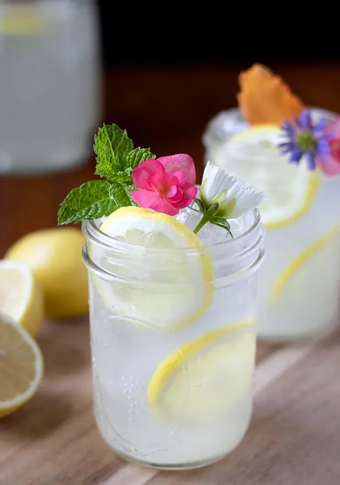 copos de limonada com hortelã e flores.' title=