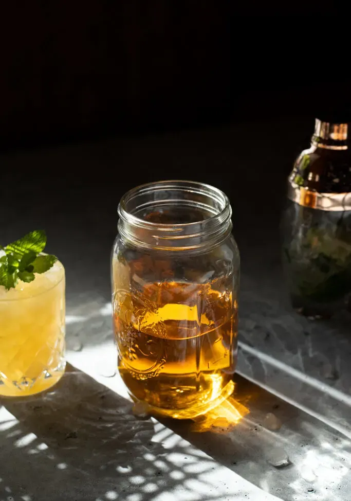 un barattolo di vetro mezzo pieno di un liquido dorato.' loading='lazy' title=