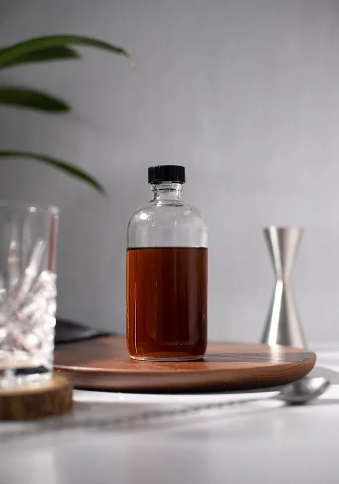 okrągła butelka bostońska z ciemnobrązowym płynem.' loading='lazy' title=