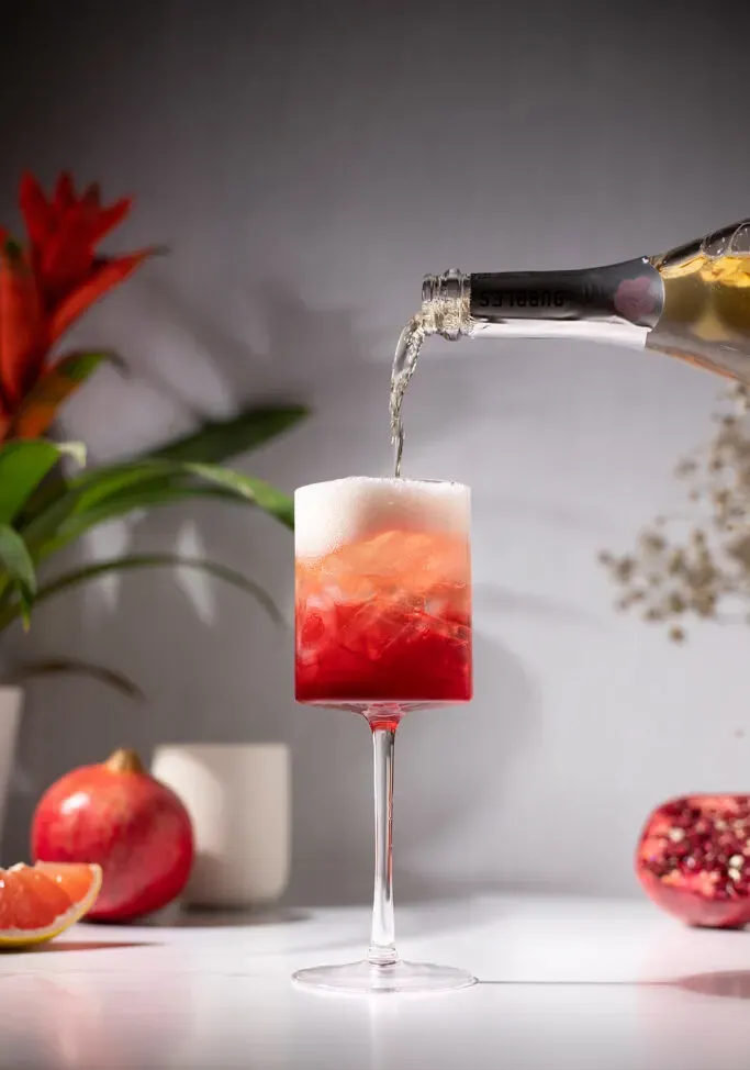 verser du rosé pétillant dans une boisson rouge.' title=