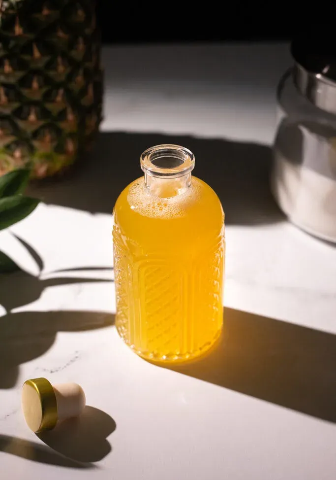 sciroppo di colore giallo brillante in una bottiglia di vetro acidato.' title=
