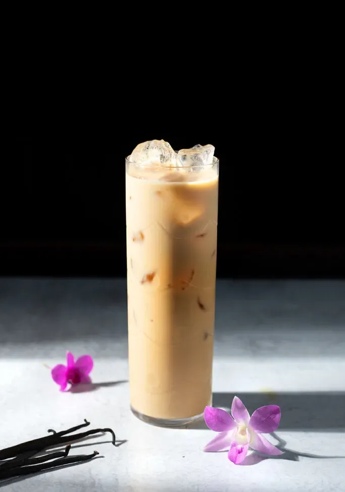 un bicchiere alto di infuso freddo con crema dolce alla vaniglia.' title=