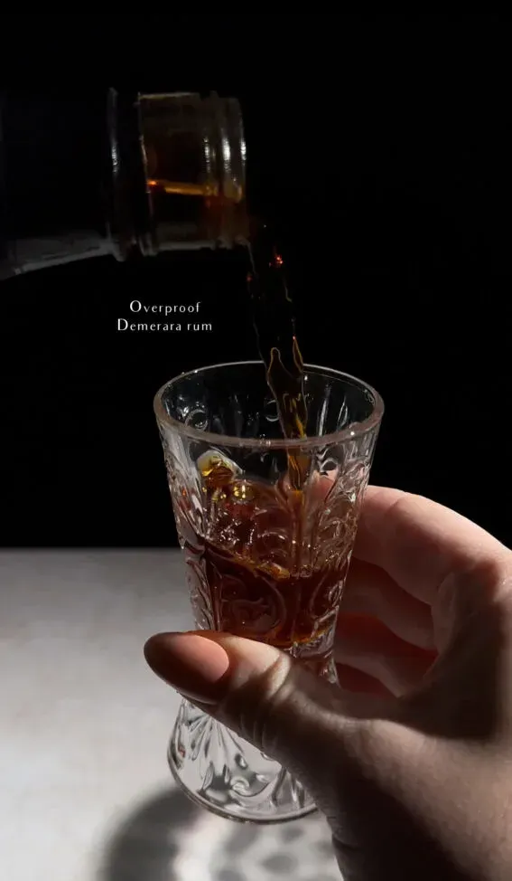 mesurer le rhum demerara dans un jigger en verre.' loading='lazy' title=