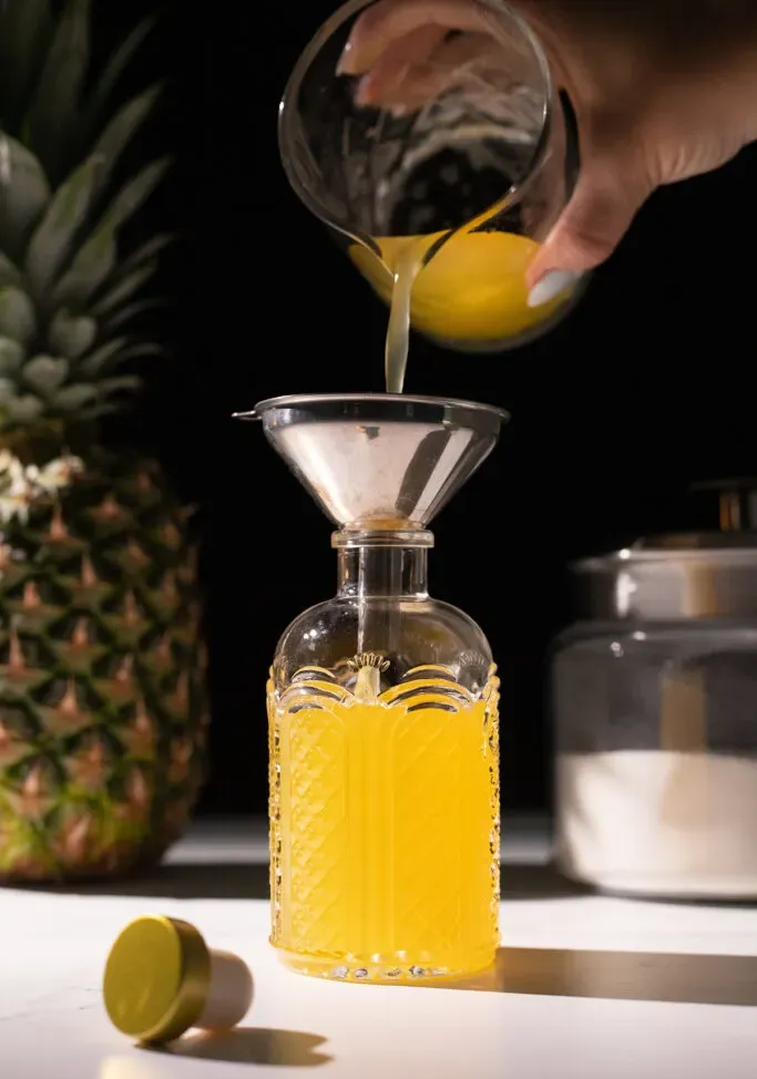 verser du sirop d'ananas dans une bouteille en verre.' title=