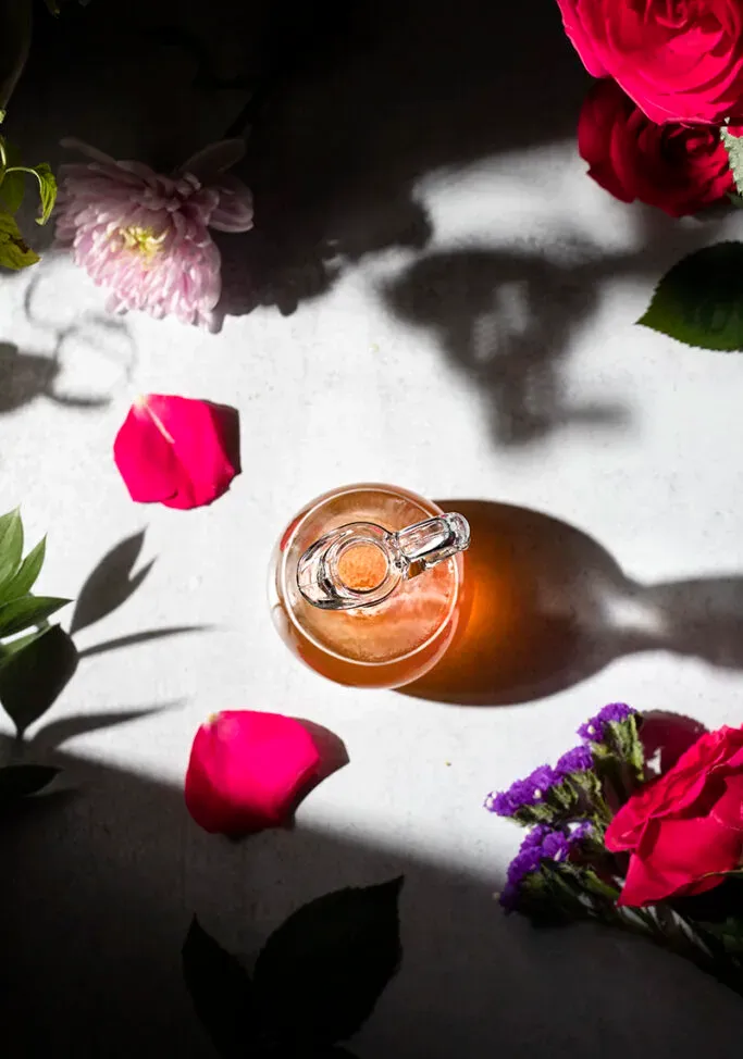 visão aérea de uma jarra de xarope de mel e flores ao sol' title=