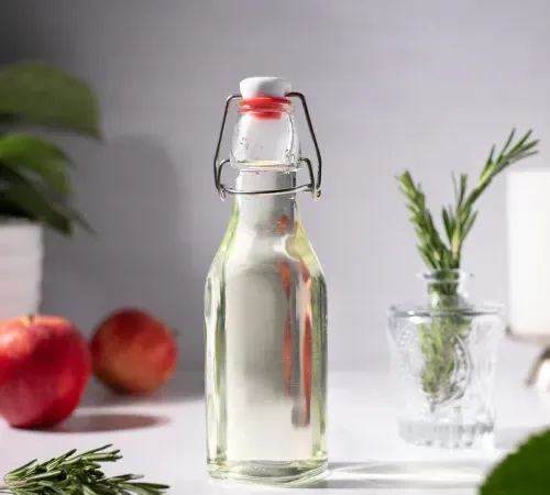 butelka z uchylnym wieczkiem wypełniona jasnozielonym syropem.' title=