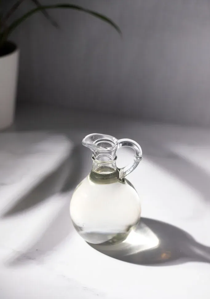 piccola brocca di vetro rotonda piena di sciroppo semplice.' title=