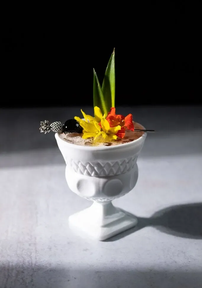 tropisches Getränk in einer weißen Glasschale mit Blumen.' loading='lazy' title=