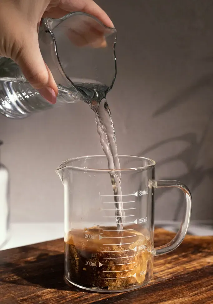 versando acqua calda nello zucchero di canna.' loading='lazy' title=