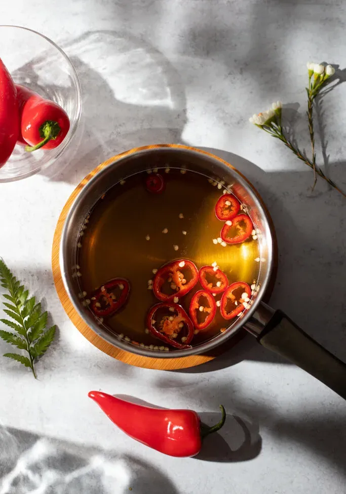 꿀과 얇게 썬 고추가 들어 있는 냄비의 머리 위 풍경' title=