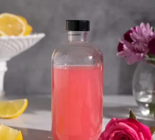 pequeña botella de boticario llena de almíbar rosa.' title=