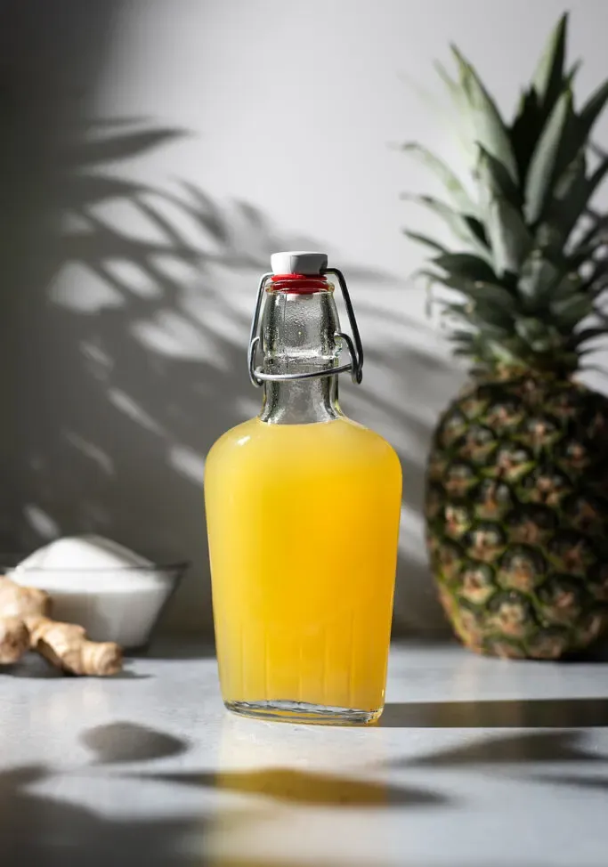 Bügelverschlussflasche mit gelbem Ananas-Ingwer-Sirup.' title=