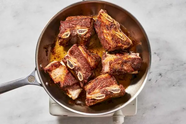 Uma frigideira grande com costelinhas douradas