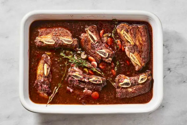 Um prato com costelinha dourada ao molho de vinho tinto