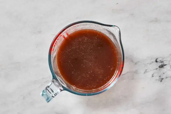 Um molho de vinho tinto em um copo medidor