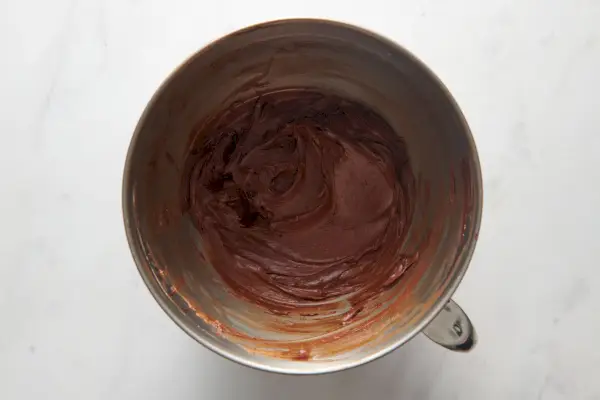 Un bol d'un batteur sur socle avec un glaçage au chocolat
