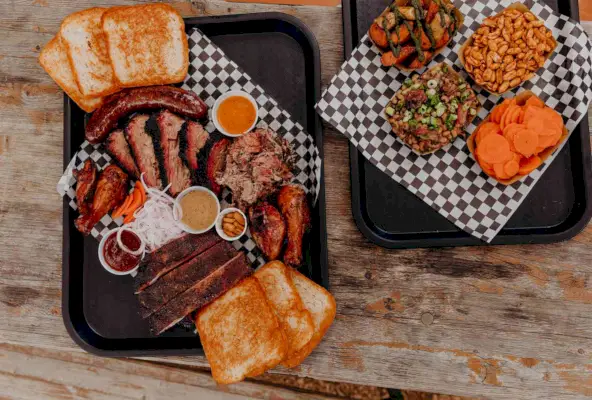 Dos bandejas de carnes ahumadas y guarniciones de parientes lejanos en Austin