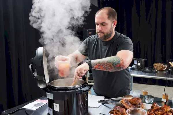 Uma pessoa mexendo o conteúdo de uma panela de pressão multiuso fumegante Instant Pot Pro Crisp & Air Fryer 8-Quart e Air Fryer